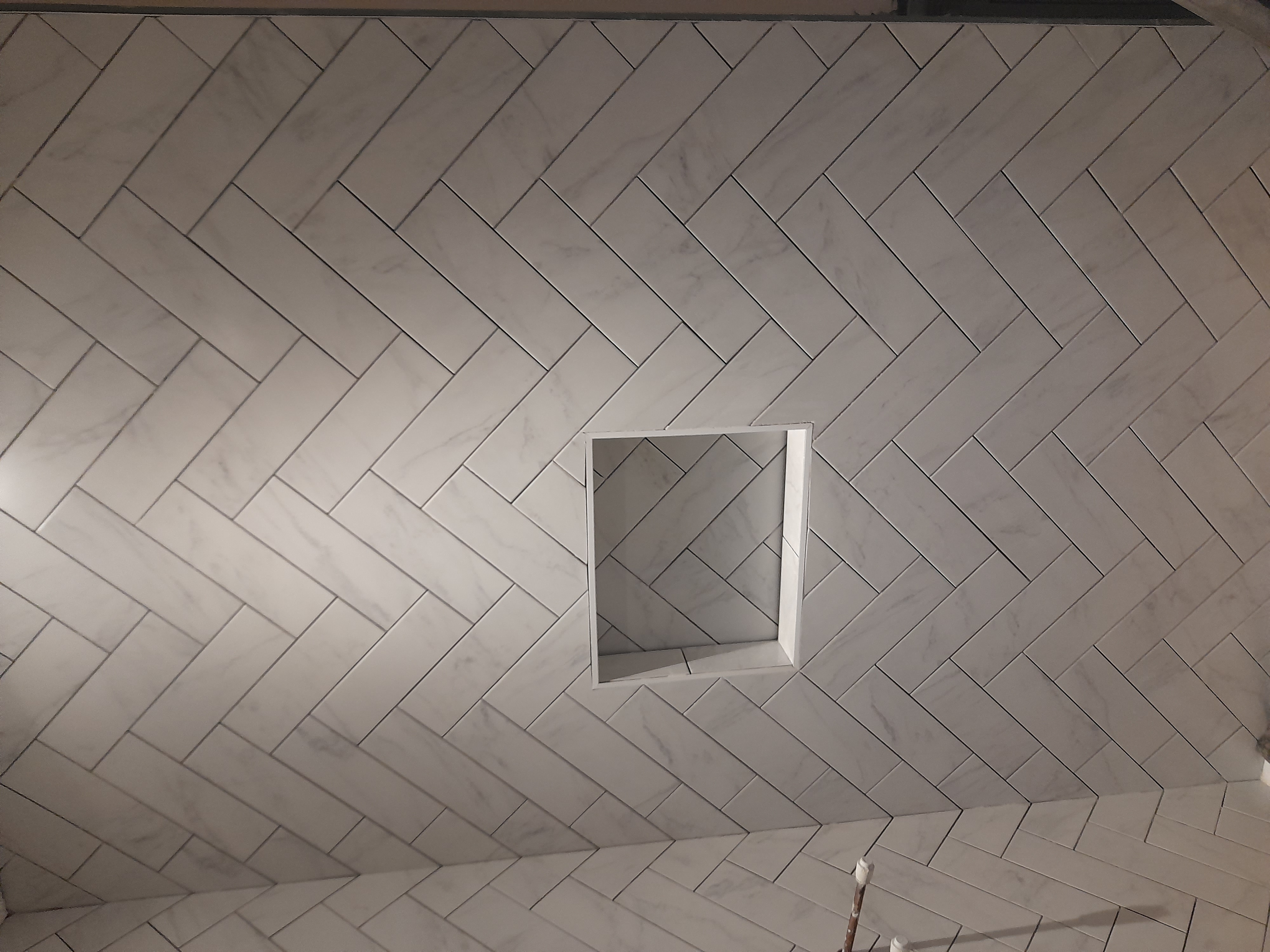 Herringbone marble shower niche